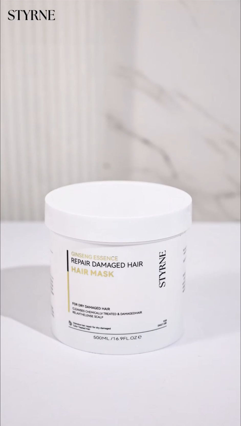 Styrne hair mask jar on a white surface with a blurred background