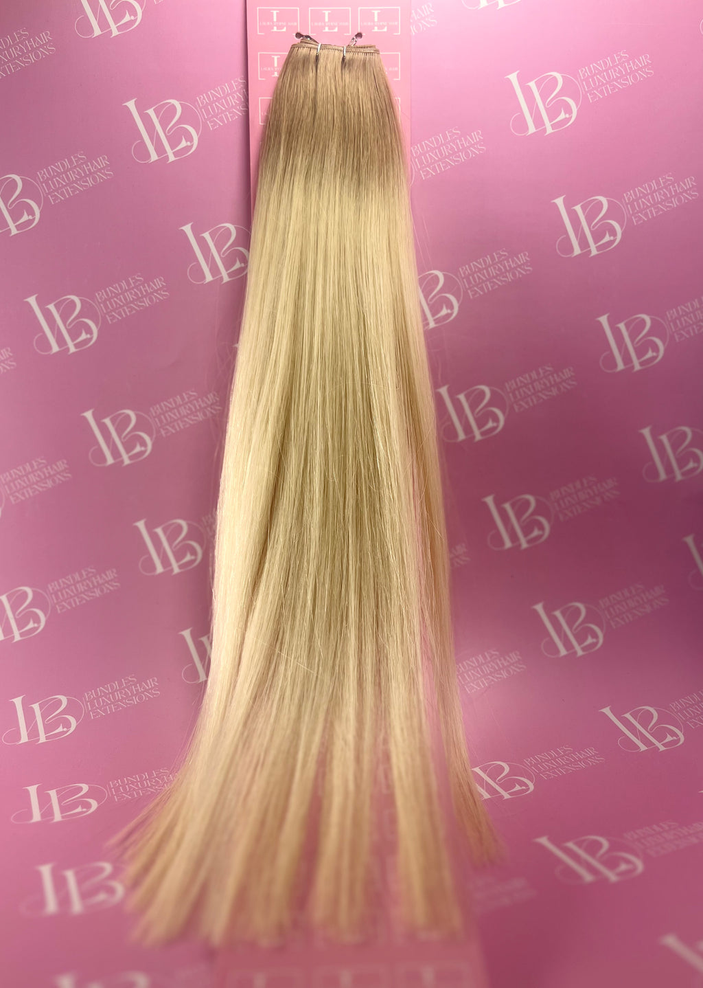 Blonde hair extensions on a pink background with 'IB' branding.