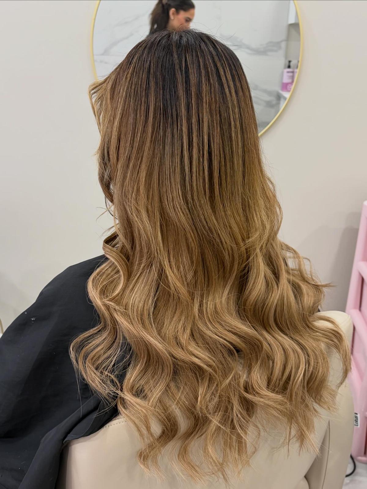 Person with wavy, ombre hair in front of a mirror.